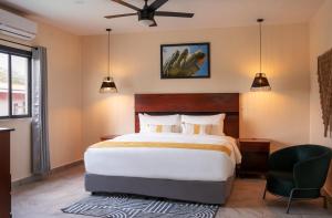 a bedroom with a large bed and a chair at The West House Boutique Hotel in San Ignacio
