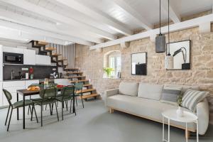 ein Wohnzimmer und eine Küche mit Sofa und Tisch in der Unterkunft Casa Cava in Pučišća
