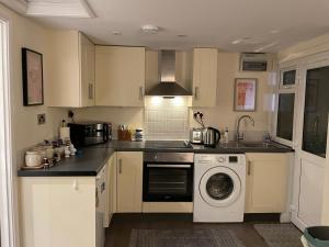 una cucina con lavatrice e lavastoviglie di The Cosy Cottage, Old Soles bridge Lane a Chorleywood
