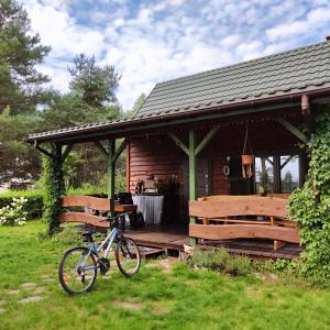 una bicicleta estacionada frente a una cabaña en Pożarowo domek na mazowszu, en Królewo