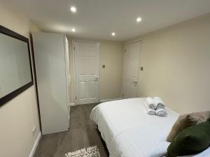 a small bedroom with a bed and a mirror at The Cosy Cottage, Old Soles bridge Lane in Chorleywood
