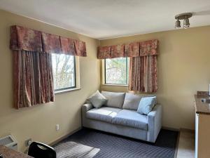 a living room with a couch and two windows at Canadian Inn in Surrey