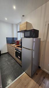 La cuisine est équipée d'un réfrigérateur et de placards en acier inoxydable. dans l'établissement Maisonnette tout confort., à Brest