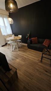 sala de estar con mesa y sofá en Maisonnette tout confort. en Brest