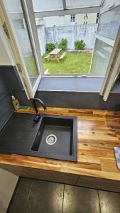 eine Küchenspüle in einem winzigen Haus mit Fenster in der Unterkunft Maisonnette tout confort. in Brest