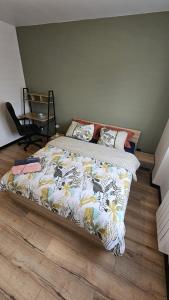 - un lit avec une couette et des oreillers dans une chambre dans l'établissement Maisonnette tout confort., à Brest