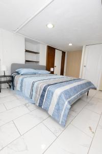 a bedroom with a bed with a blue and white blanket at 3-Bed Luxurious Home Close to NYC in Jersey City