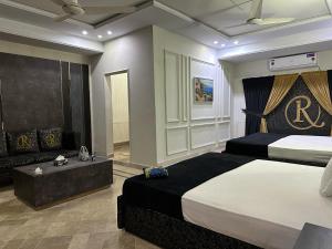 ein Hotelzimmer mit 2 Betten und einem Sofa in der Unterkunft The Royal Residency in Islamabad