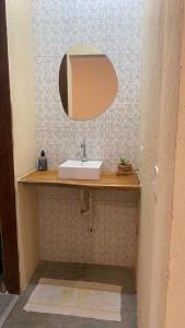 a bathroom with a sink and a mirror at Milagres Retrô- Studio in São Miguel dos Milagres