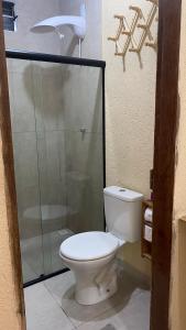 a bathroom with a toilet and a glass shower at Milagres Retrô- Studio in São Miguel dos Milagres