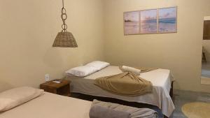 a hospital room with two beds and a lamp at Milagres Retrô- Studio in São Miguel dos Milagres