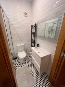 a bathroom with a white toilet and a sink at Bluebell Cottage - with hottub in Newry