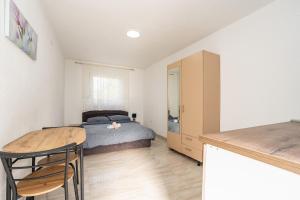 a bedroom with a bed and a wooden table at Apartments and Rooms STIPANOVI DVORI in Donji Karin