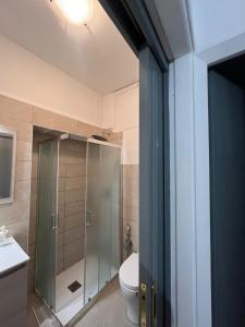 a bathroom with a toilet and a glass shower at Sweet Lotus Apartment in Taormina +5 photos