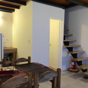 a living room with a table and a staircase at Ukurj Apartamentos in Ushuaia