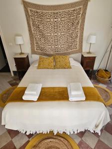 1 cama grande con 2 toallas encima en DOM COUÇO, en Couço