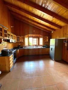 a large kitchen with wooden walls and a refrigerator at Groën Chincha® Casa de Campo centrica y turistica in San Pedro