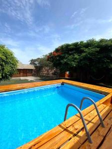 uma grande piscina azul com um deque de madeira em Groën Chincha® Casa de Campo centrica y turistica em San Pedro