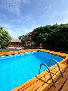 a large blue swimming pool with a wooden deck at Groën Chincha® Casa de Campo centrica y turistica in San Pedro