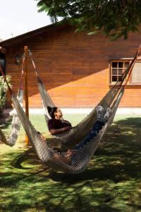 two people sitting in a hammock in a yard at Groën Chincha® Casa de Campo centrica y turistica in San Pedro