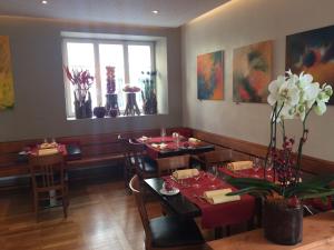 una sala da pranzo con tavoli e sedie e una finestra di Auberge de Prangins a Prangins Altre 23 foto
