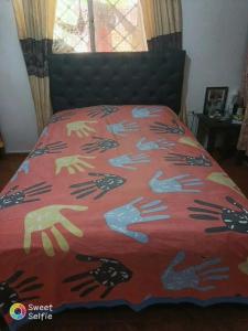a bed with a red comforter with a black head board at MINIMO 3 NOCHES HABITACION APARTAMENTO COMPARTIDO 3 PERSONAS - Aire acondicionado in Valledupar
