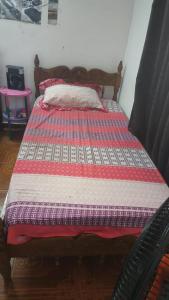 a bed with a red and white quilt on it at MINIMO 3 NOCHES HABITACION APARTAMENTO COMPARTIDO 3 PERSONAS - Aire acondicionado in Valledupar