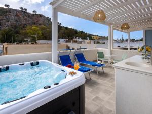 a hot tub on a patio with a table and chairs at IL FARO E LA LUNA Beach Apartments in San Vito lo Capo