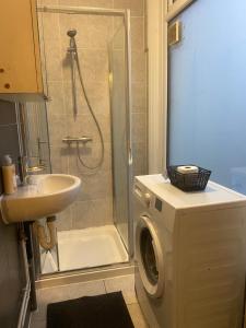 a bathroom with a shower and a sink and a washing machine at Studio flat/Close to central in Hendon