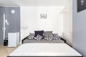 ein Schlafzimmer mit einem Bett mit Kissen darauf in der Unterkunft Le Grey Cocon - Studio cosy aux portes de Paris in Saint-Mandé
