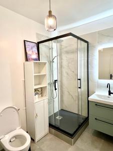 a bathroom with a shower and a toilet and a sink at Confortable et Chic Appartement in Courbevoie