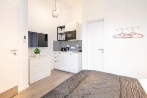 ein weißes Schlafzimmer mit Bett und Küche in der Unterkunft Extreme Central - Modern Mini Studio in Budapest