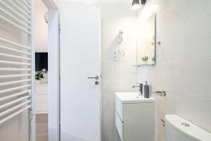 ein weißes Badezimmer mit Waschbecken und Spiegel in der Unterkunft Extreme Central - Modern Mini Studio in Budapest + 12 Fotos