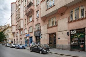 ein Auto, das vor einem Gebäude in einer Straße geparkt ist in der Unterkunft Extreme Central - Modern Mini Studio in Budapest