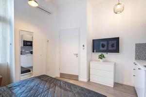 ein Schlafzimmer mit einem Bett und einem Fernseher an der Wand in der Unterkunft Extreme Central - Modern Mini Studio in Budapest