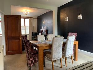 a dining room with a wooden table and chairs at Beautifully Styled 2BR Home with Garden in Manchester