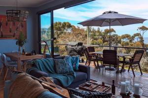 a living room with a couch and a table with an umbrella at Crow's Nest - Couples Retreat in Eaglehawk Neck