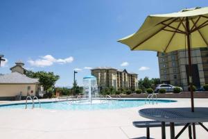 a swimming pool with an umbrella and a fountain at Simply Blessed Mountain View 1605 in Pigeon Forge