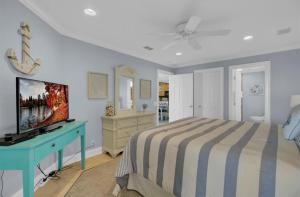 - une chambre avec un lit et un bureau bleu avec une télévision dans l'établissement 113 Seascape by AvantStay Amazing Ocean Views Communal Pool, à Isle of Palms