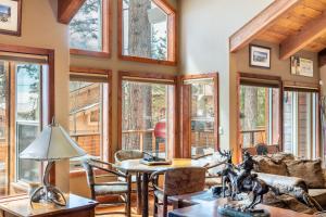 a living room with windows and a table at Frosted Shore by AvantStay Luxury Lake Views in Incline Village