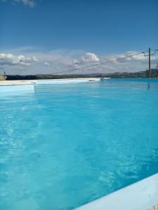 uma piscina de água azul com uma ponte ao fundo em Solar do Prazo em Gonçalo