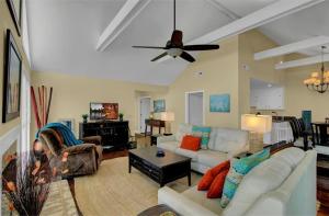 a living room with couches and a ceiling fan at 15 Lake Village by AvantStay Golf Course Lagoon Views in Isle of Palms