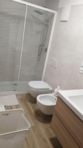 a white bathroom with a toilet and a shower at Bio house posto auto aria condizionata in Bologna