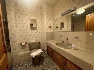 a bathroom with a sink and a toilet and a mirror at 80's Grandma London Experience ! in London