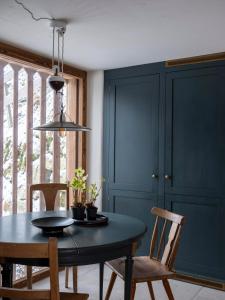 a dining room with a black table and chairs at Green Chalet from Centuries ago in Reith bei Kitzbühel +6 photos