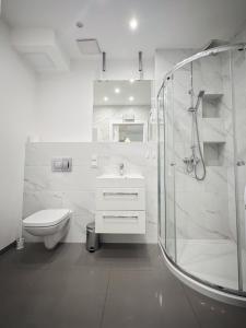 a white bathroom with a shower and a toilet at 306 BALTICA Hallera 223 Apartamenty zresetuj się w Gdańsku blisko morza in Gdańsk