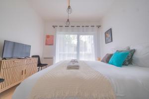 a bedroom with a large white bed and a window at Studio Boulingrin - Hypercentre in Reims