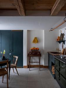 a kitchen with blue cabinets and a table with a bowl of oranges at Green Chalet from Centuries ago in Reith bei Kitzbühel