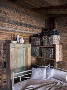 a bedroom with wooden walls with a bed and baskets at Green Chalet from Centuries ago in Reith bei Kitzbühel