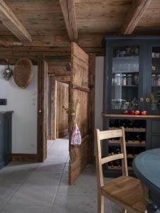 a kitchen with a wooden door and a table and chair at Green Chalet from Centuries ago in Reith bei Kitzbühel